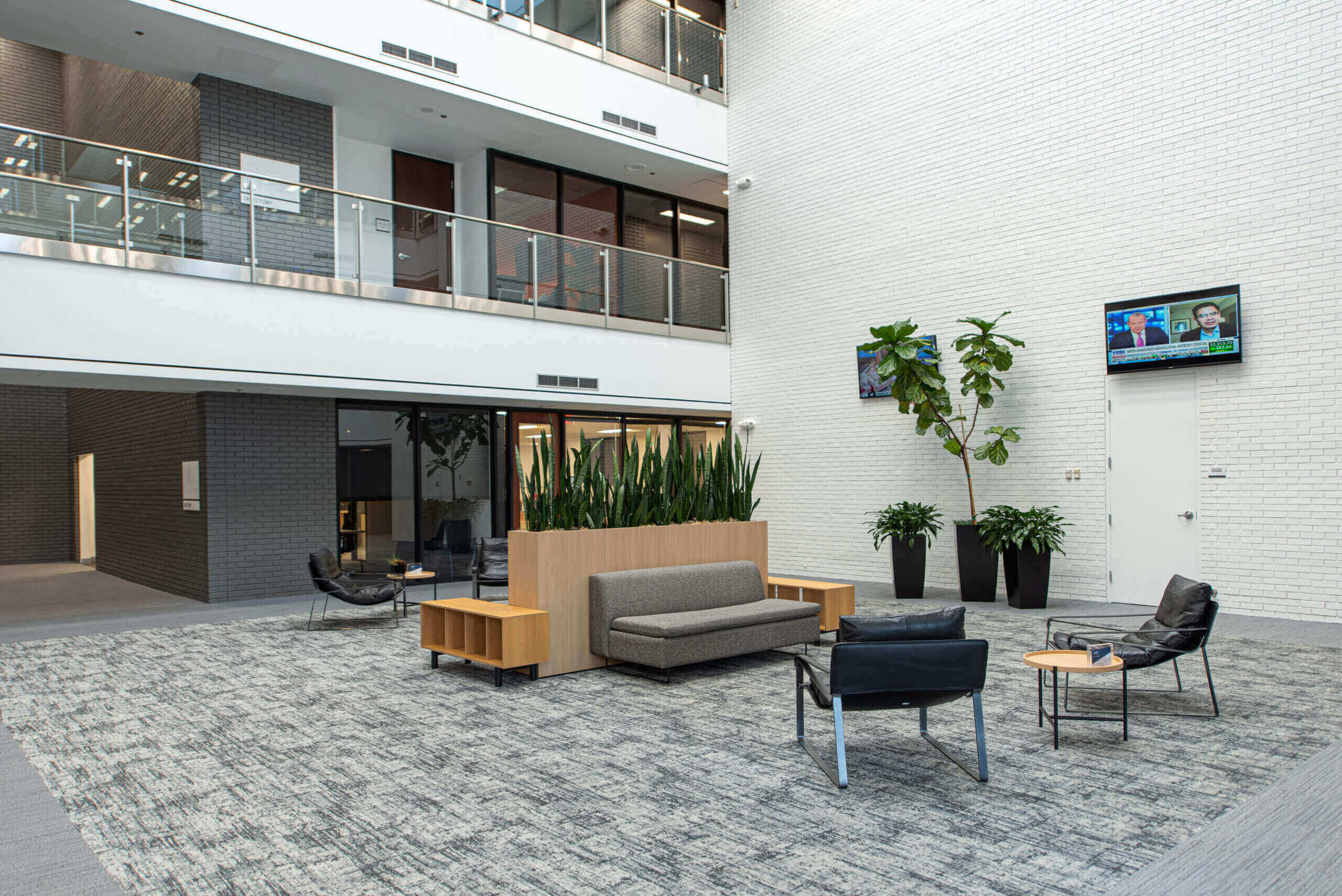 A lobby area with couches, chairs and tables.